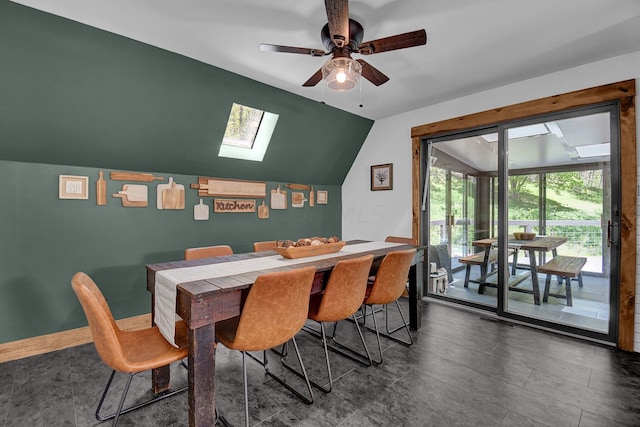 dining area featuring ceiling fan and vaulted ceiling with skylight