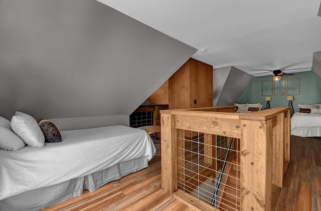 bedroom with wood-type flooring and vaulted ceiling