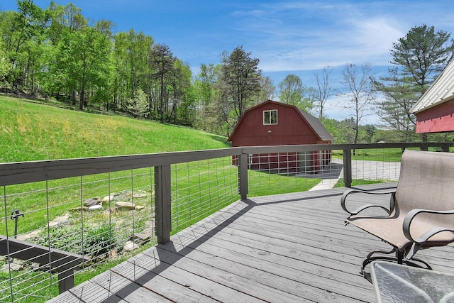 wooden terrace with an outdoor structure and a lawn