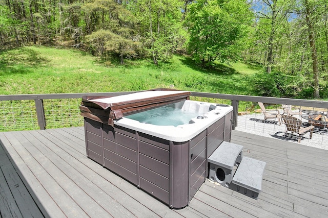 wooden deck featuring a lawn and a hot tub