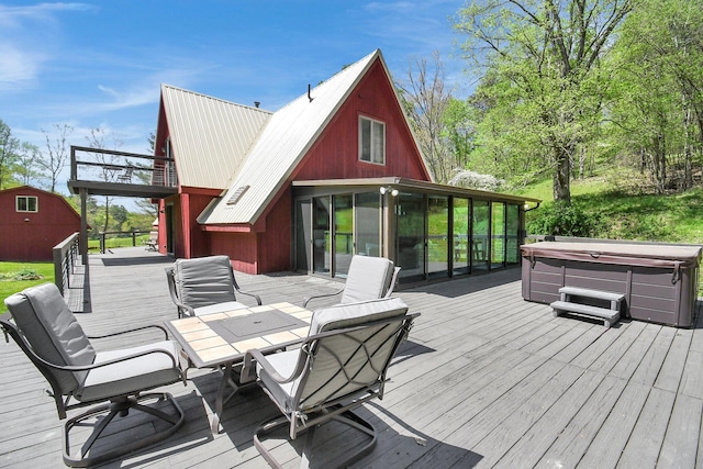 deck featuring a hot tub and a sunroom