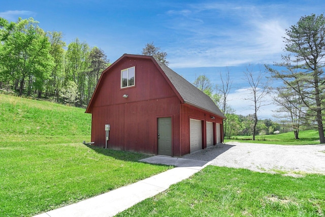 view of outdoor structure featuring a lawn and a garage