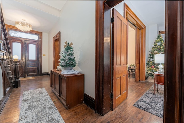 foyer entrance featuring dark wood-type flooring and lofted ceiling