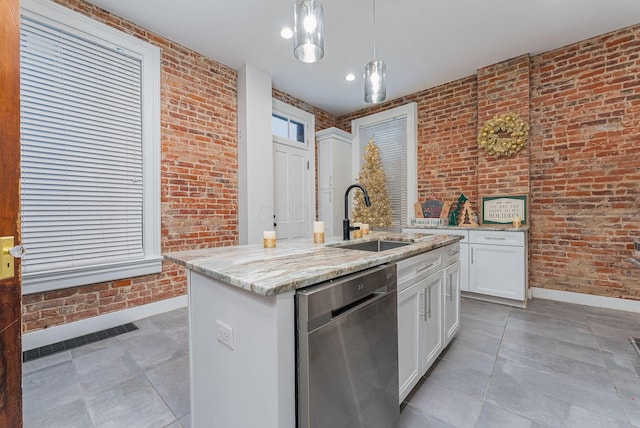 kitchen featuring dishwasher, hanging light fixtures, and brick wall