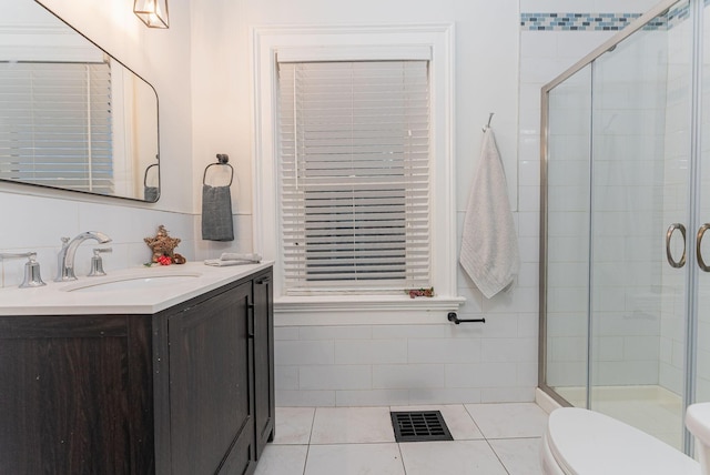 bathroom with tile patterned flooring, vanity, a shower with door, and toilet