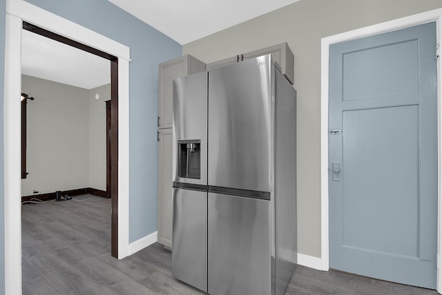 kitchen with stainless steel refrigerator with ice dispenser and light hardwood / wood-style floors