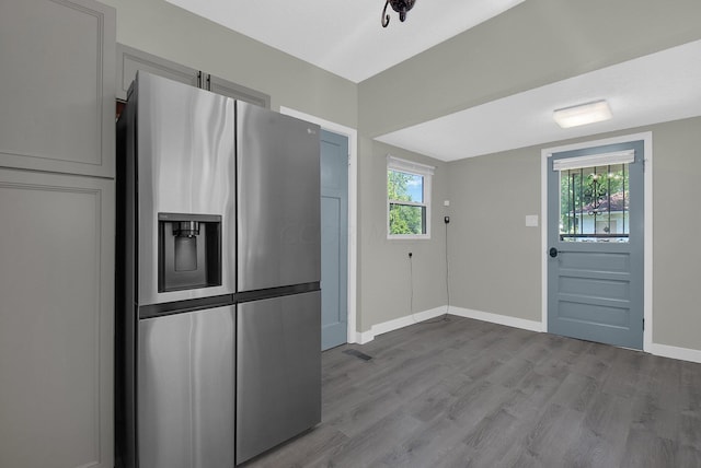 kitchen with stainless steel fridge with ice dispenser and light hardwood / wood-style flooring