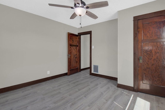 spare room with ceiling fan and light wood-type flooring