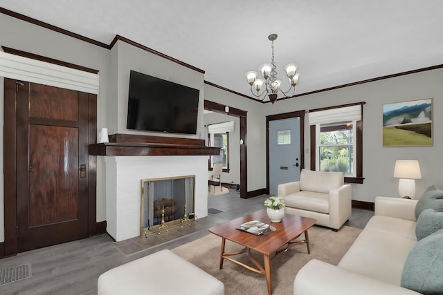 living room featuring hardwood / wood-style flooring, ornamental molding, and an inviting chandelier