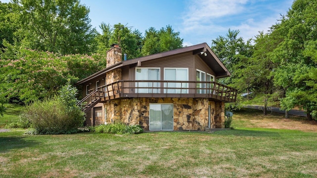 rear view of house featuring a yard and a wooden deck