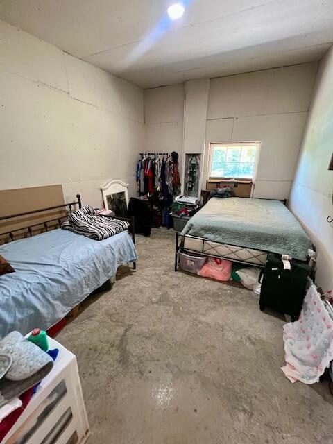 bedroom featuring concrete flooring