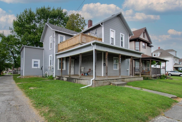 view of front facade with covered porch, a balcony, and a front lawn