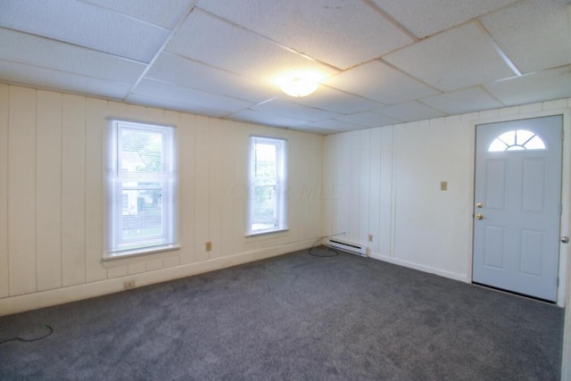 entryway with dark colored carpet, a drop ceiling, and a baseboard radiator