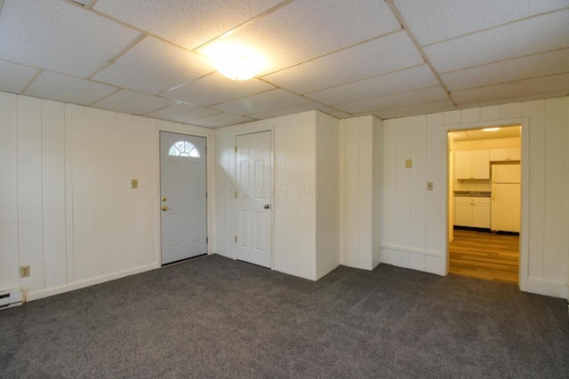 entryway featuring dark colored carpet and a paneled ceiling