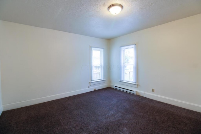 carpeted spare room featuring a textured ceiling and a baseboard radiator