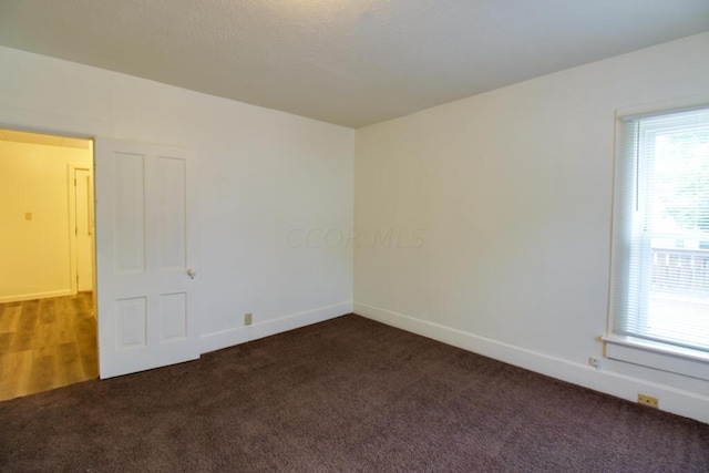 empty room featuring dark colored carpet