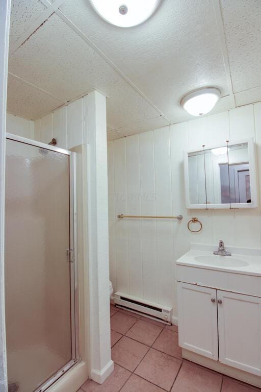 bathroom featuring vanity, tile patterned floors, toilet, baseboard heating, and walk in shower