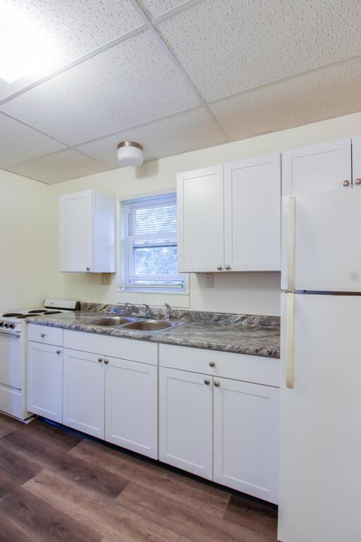 kitchen featuring white appliances, dark hardwood / wood-style floors, and white cabinetry