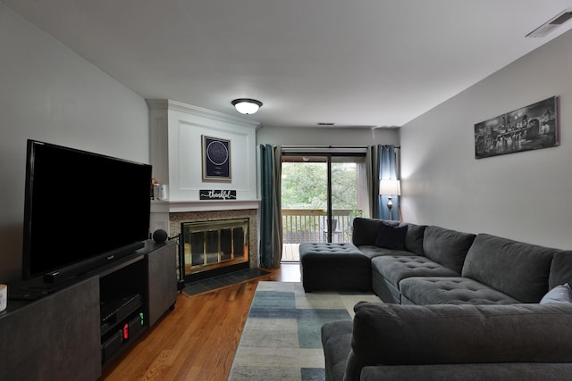 living room with light hardwood / wood-style floors and a tiled fireplace