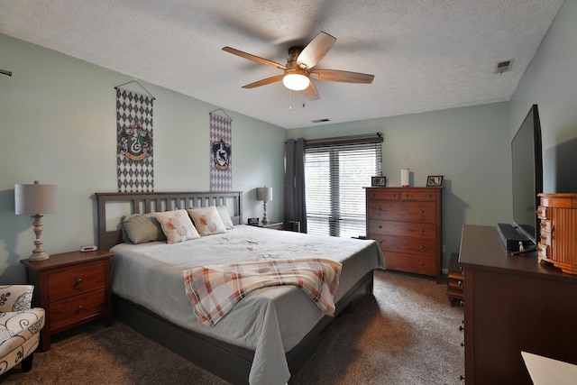 bedroom featuring a textured ceiling, dark carpet, and ceiling fan