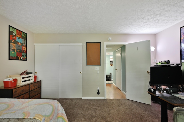 bedroom featuring a closet, light colored carpet, and a textured ceiling