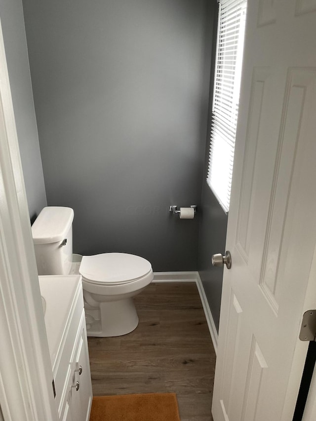 bathroom featuring vanity, hardwood / wood-style flooring, plenty of natural light, and toilet