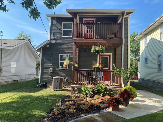 rear view of property with a balcony, a lawn, and central air condition unit