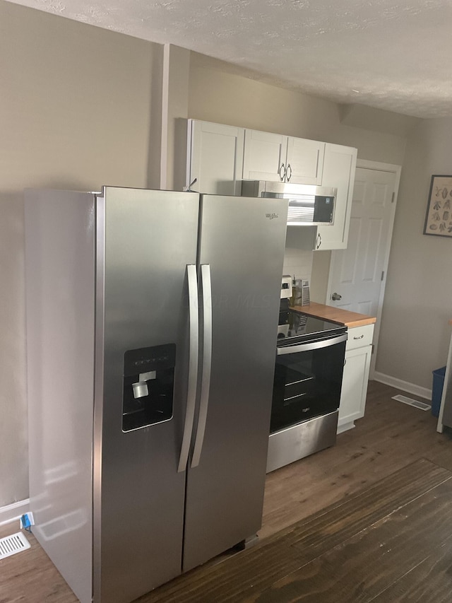 kitchen with stainless steel appliances, dark hardwood / wood-style floors, white cabinets, and wood counters