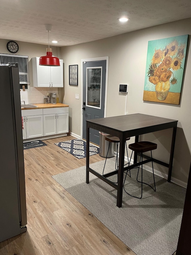 dining area with a textured ceiling and light wood-type flooring