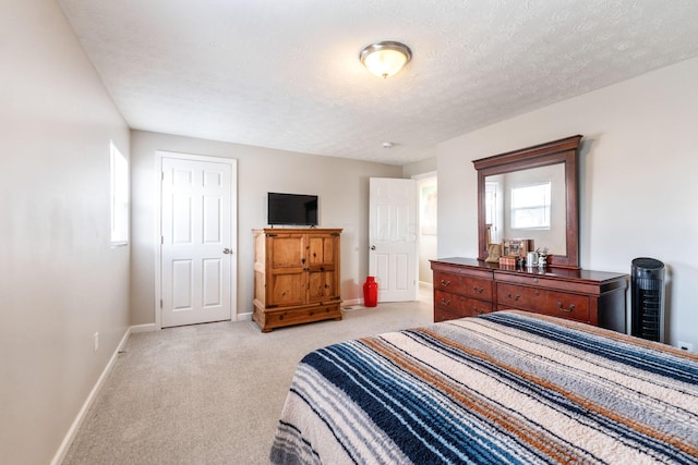 bedroom featuring light colored carpet and a textured ceiling