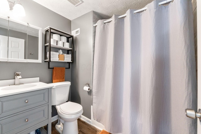 bathroom with hardwood / wood-style flooring, vanity, a textured ceiling, a shower with curtain, and toilet