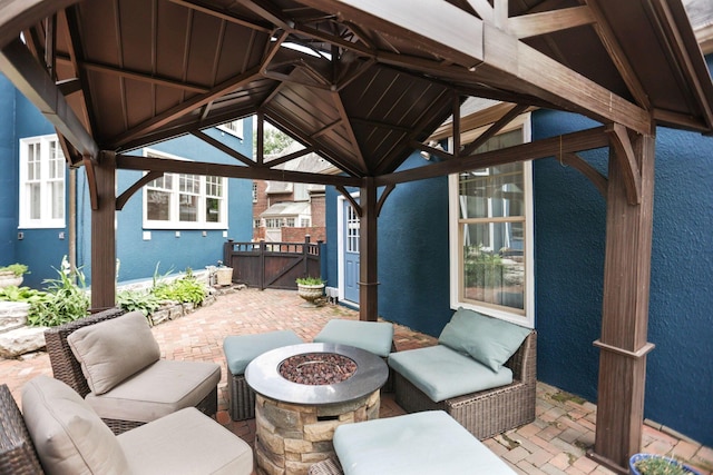 view of patio / terrace featuring a gazebo and an outdoor living space with a fire pit