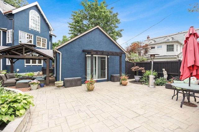 back of house with a gazebo, an outdoor structure, and a patio area