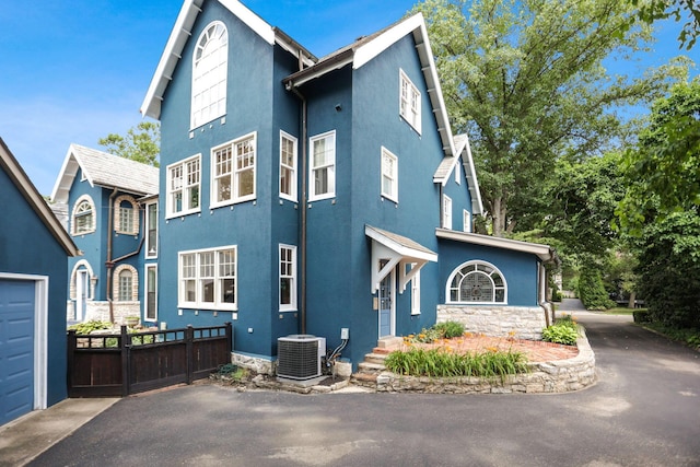 view of front of home featuring cooling unit and a garage