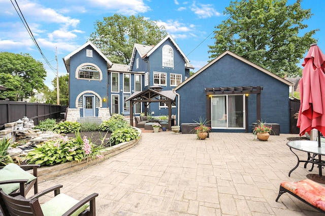 rear view of house featuring a gazebo, an outdoor hangout area, and a patio