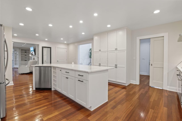 kitchen featuring white cabinetry, light stone countertops, dark hardwood / wood-style flooring, and fridge