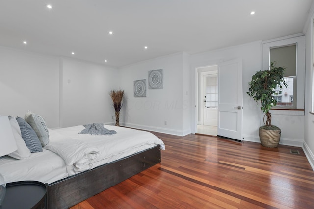 bedroom featuring crown molding and dark hardwood / wood-style flooring