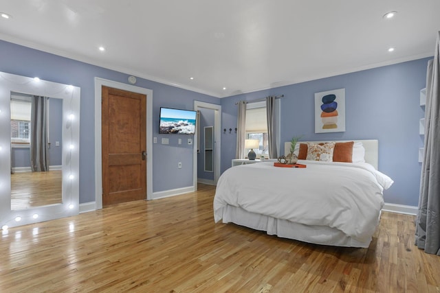 bedroom featuring ornamental molding and light wood-type flooring