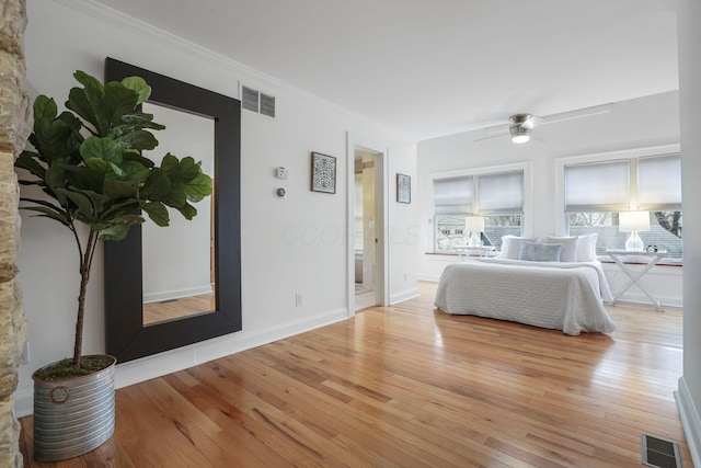 bedroom with crown molding, ceiling fan, and light wood-type flooring