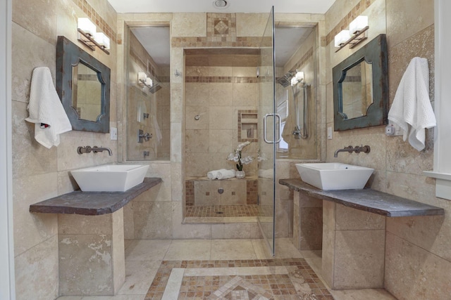 bathroom featuring tile walls, sink, and a shower with door