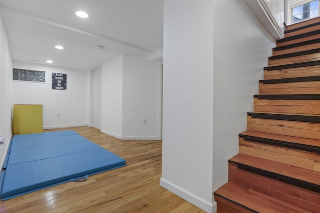 exercise room with light hardwood / wood-style flooring