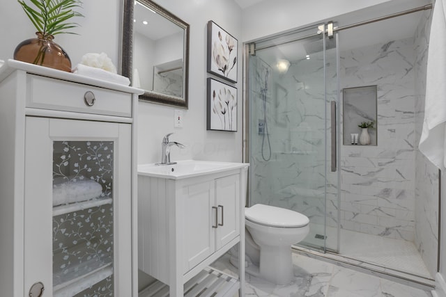 bathroom with vanity, a shower with door, and toilet