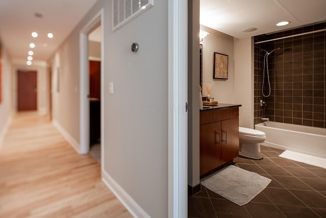 full bathroom featuring tiled shower / bath combo, vanity, tile patterned flooring, and toilet