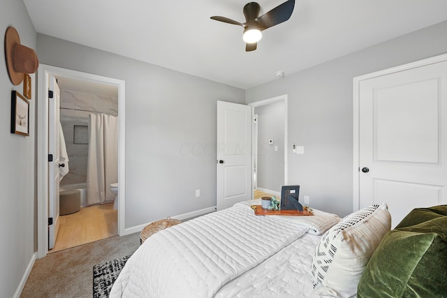 carpeted bedroom with ensuite bathroom and ceiling fan