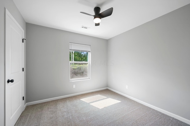 empty room featuring ceiling fan and carpet