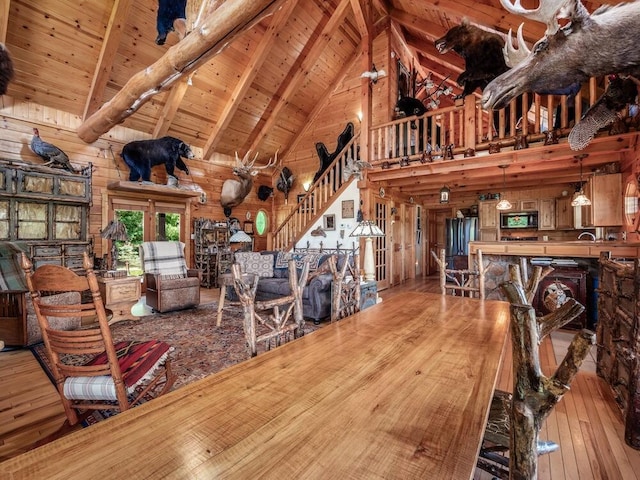 living room featuring wood ceiling, hardwood / wood-style flooring, high vaulted ceiling, beamed ceiling, and wood walls