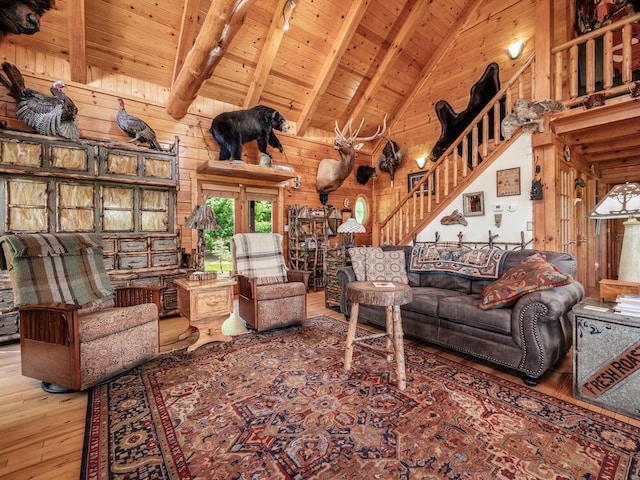 living room with beam ceiling, hardwood / wood-style flooring, wood walls, and wood ceiling