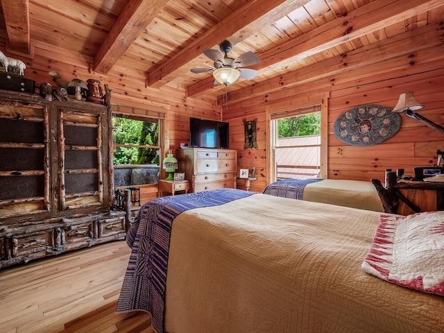 bedroom featuring hardwood / wood-style floors, beam ceiling, access to exterior, and wooden walls