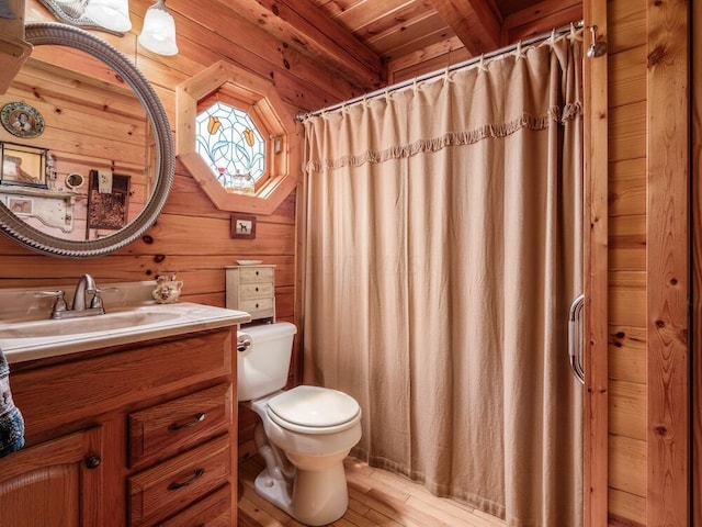 bathroom featuring beamed ceiling, wood-type flooring, toilet, wooden walls, and wood ceiling