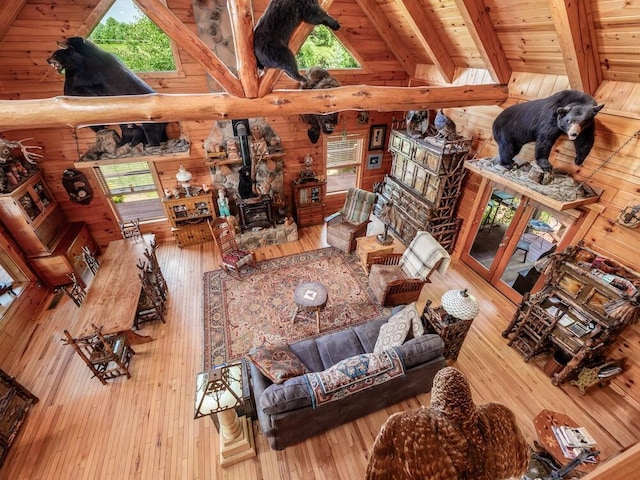 living room featuring wood-type flooring, a wood stove, and wood walls